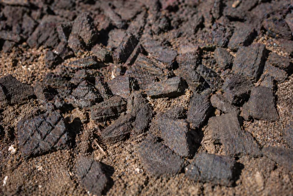 Close up of dark brown rubber mulch nuggets showing texture and color retention